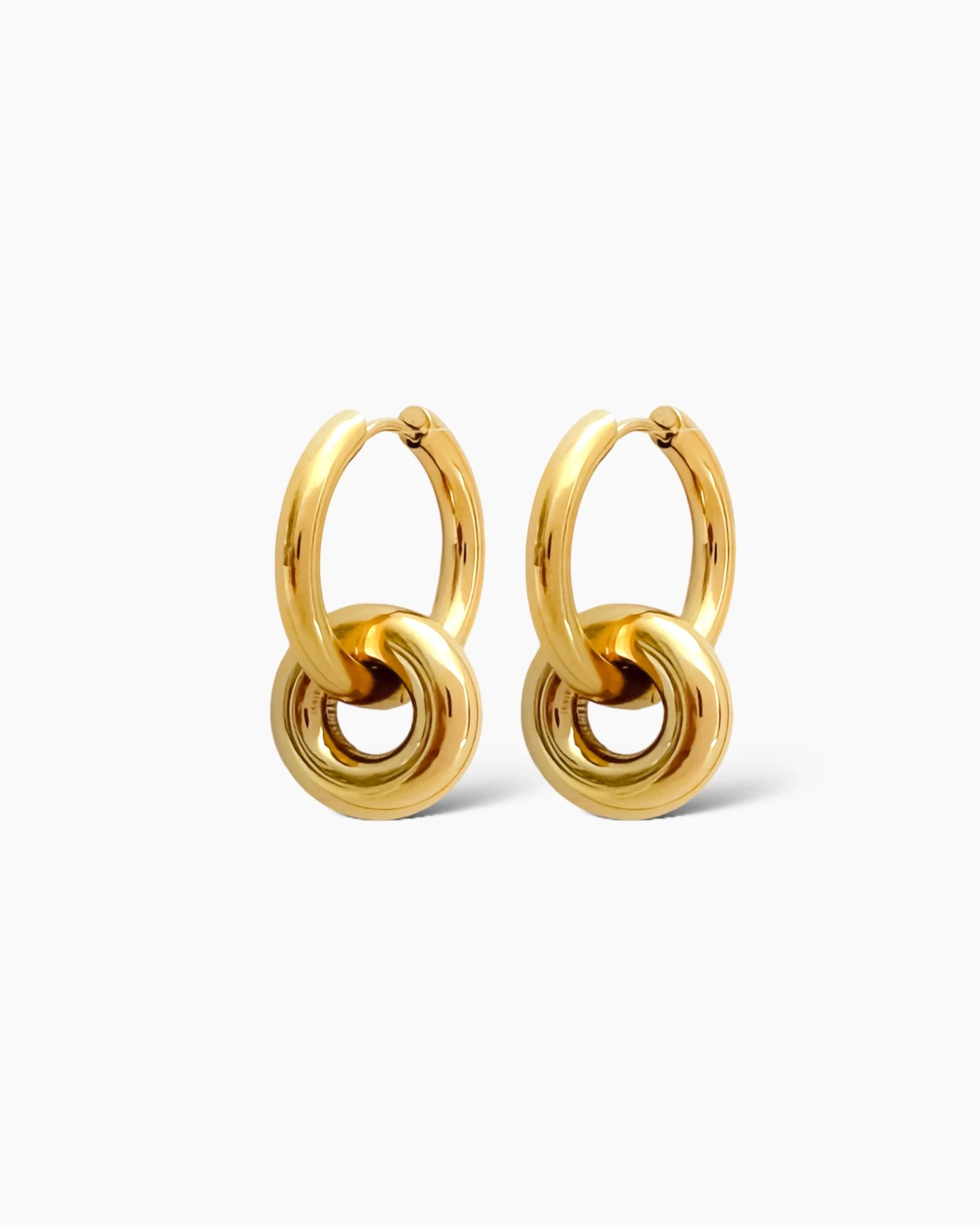Son aros de acero dorado con diseño liso y cierre de clip. Llevan otro aro entrelazado que es extraible. en acero inoxidable bañado en oro de 18k.