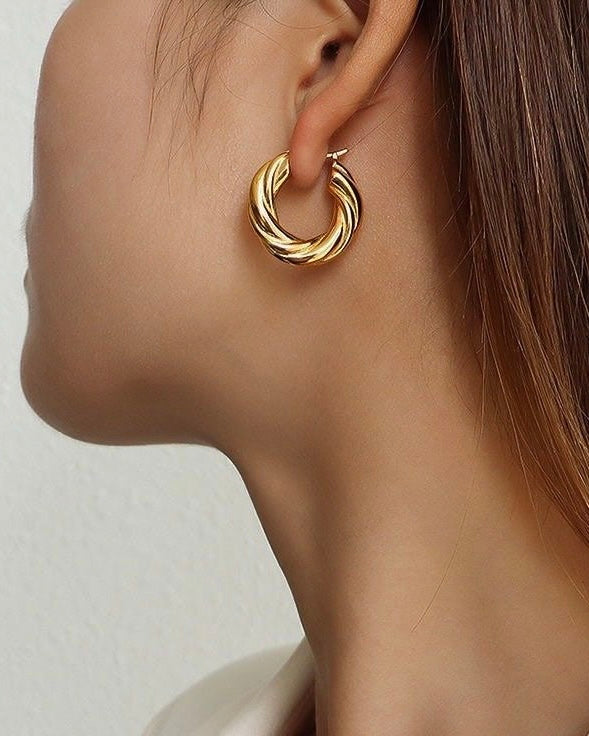 Aros básicos gruesos diseño torcidos en acero baño de oro 18K Revolve
