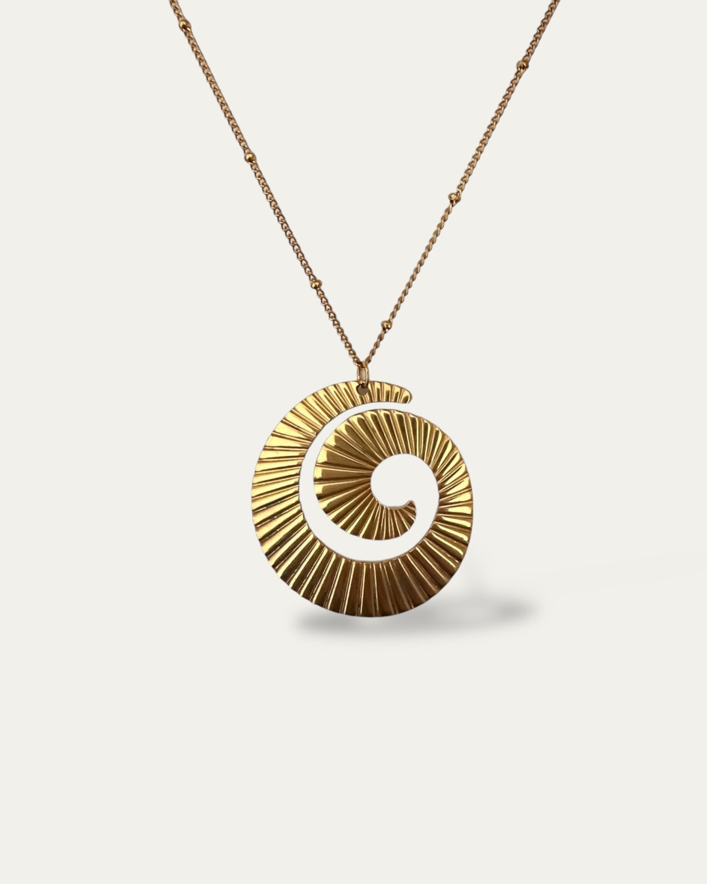 Colgante grande en forma de espiral en acero inoxidable acabado oro mate Úrsula