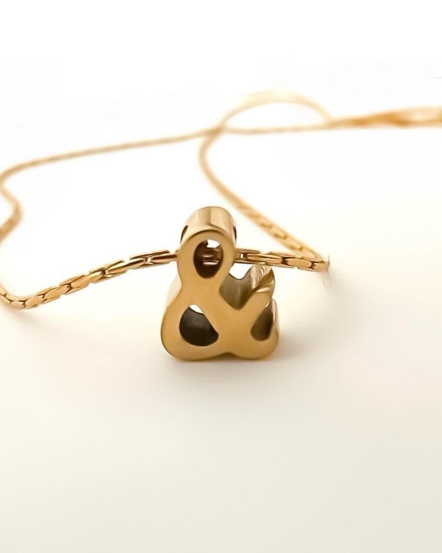 Collar corto cadena fina con colgante minimalista con forma de ampersand en acero baño oro 18K “&”