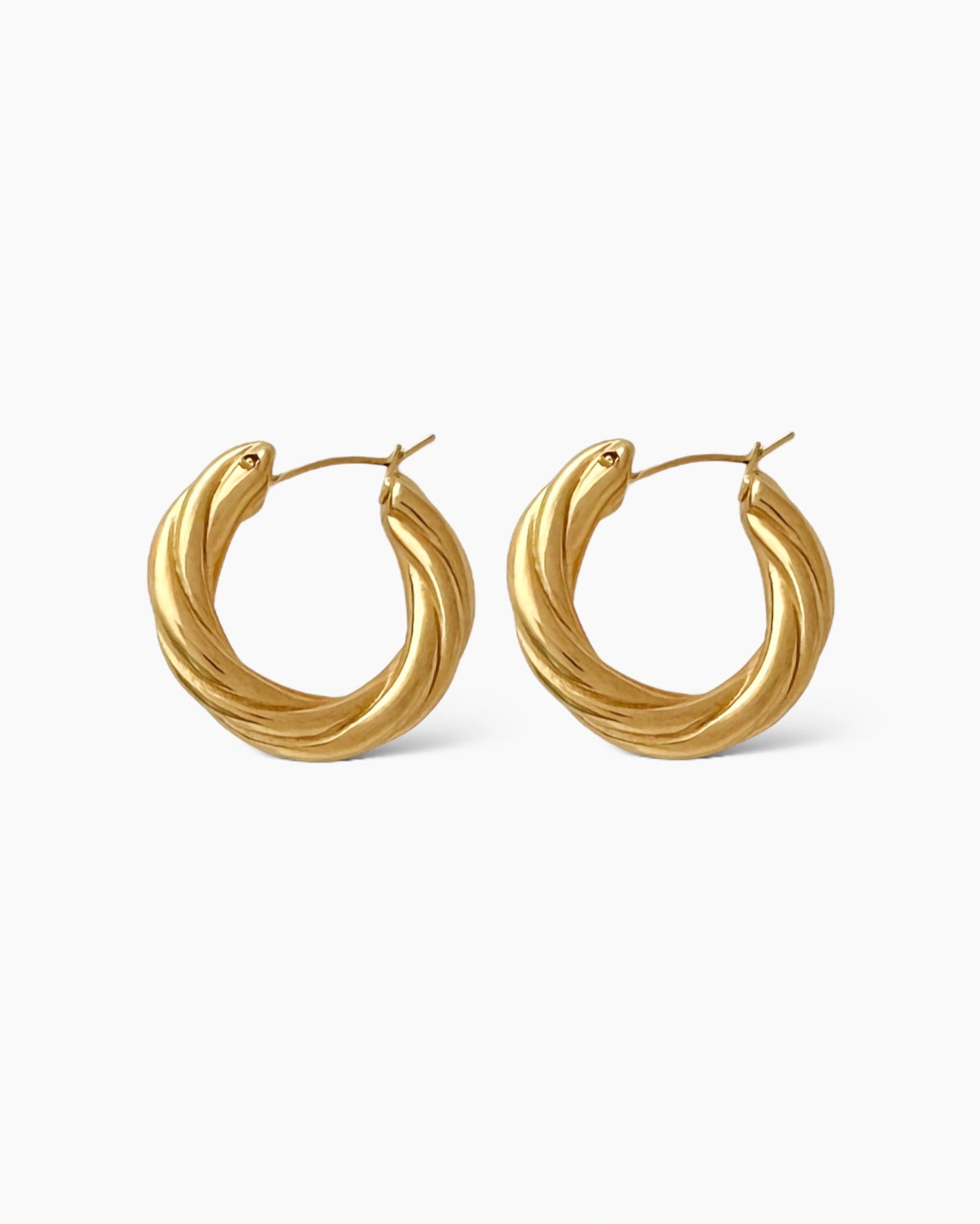 Aros de tamaño mediano con diseño torcido, en acero inoxidable bañado en oro de 18k.