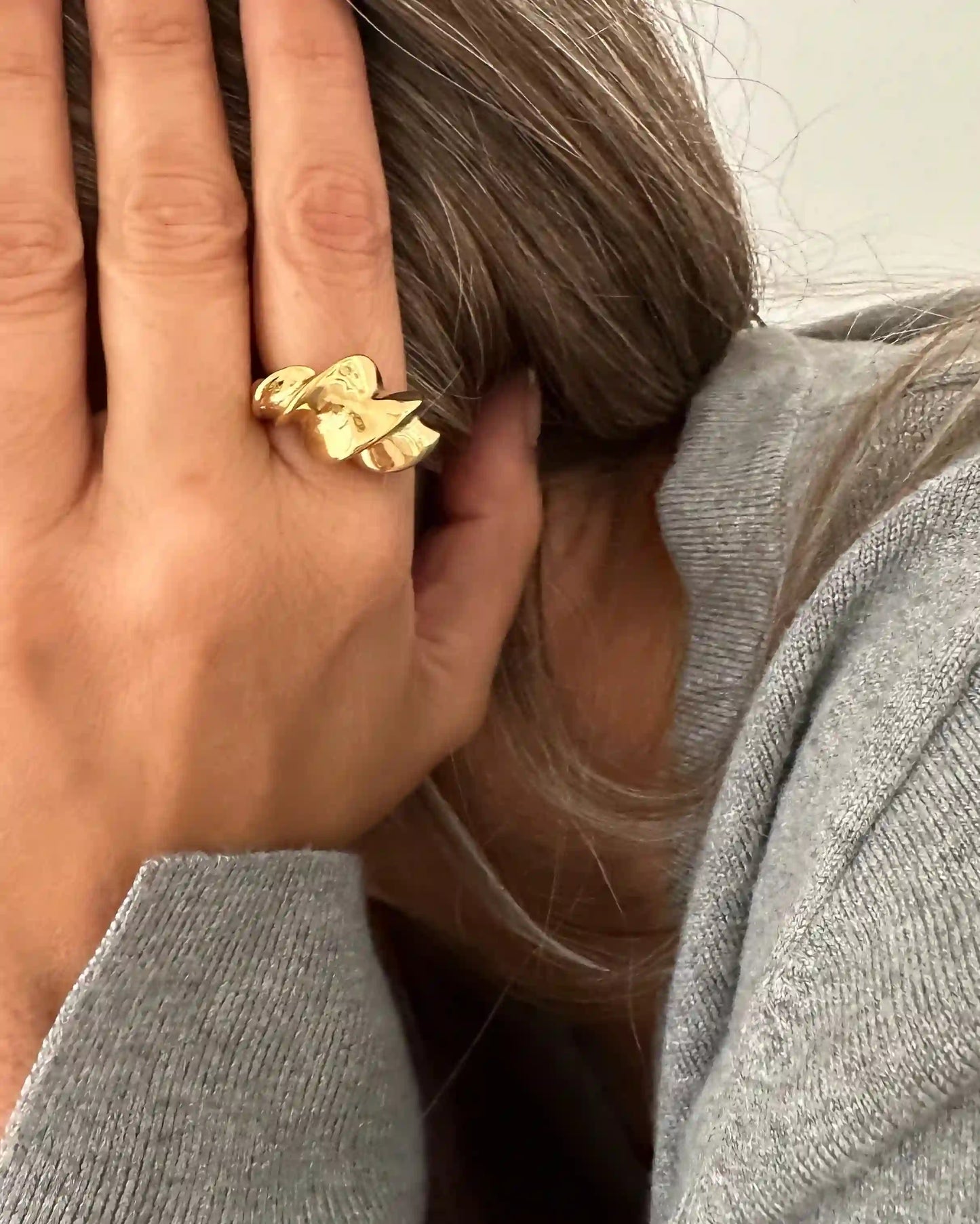 Este anillo tiene un diseño enrollado y retorcido, fabricado en acero inoxidable bañado en oro.