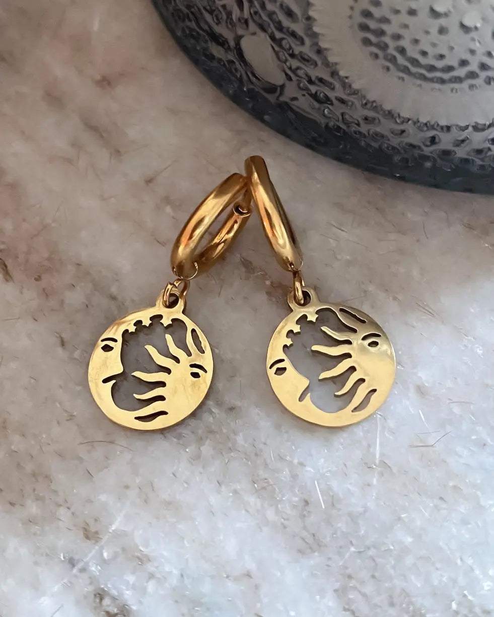 Son unos aritos de acero inoxidable con baño de oro y colgante de medallita de sol y luna.