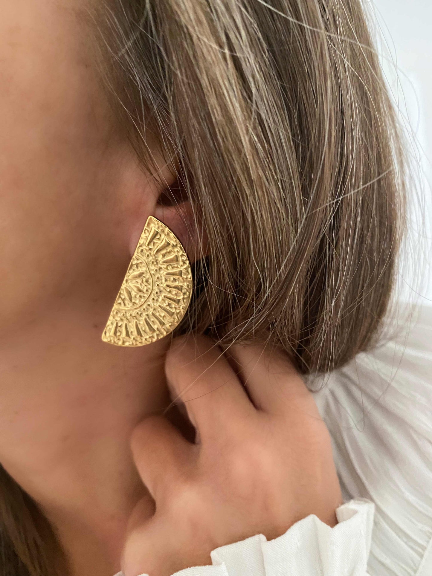 Los PENDIENTES POMELO son unos pendientes originales y elegantes, con forma de semicírculo labrado con motivos de rayos de SOL. Están realizados en acero inoxidable y acabados en ORO 18k.