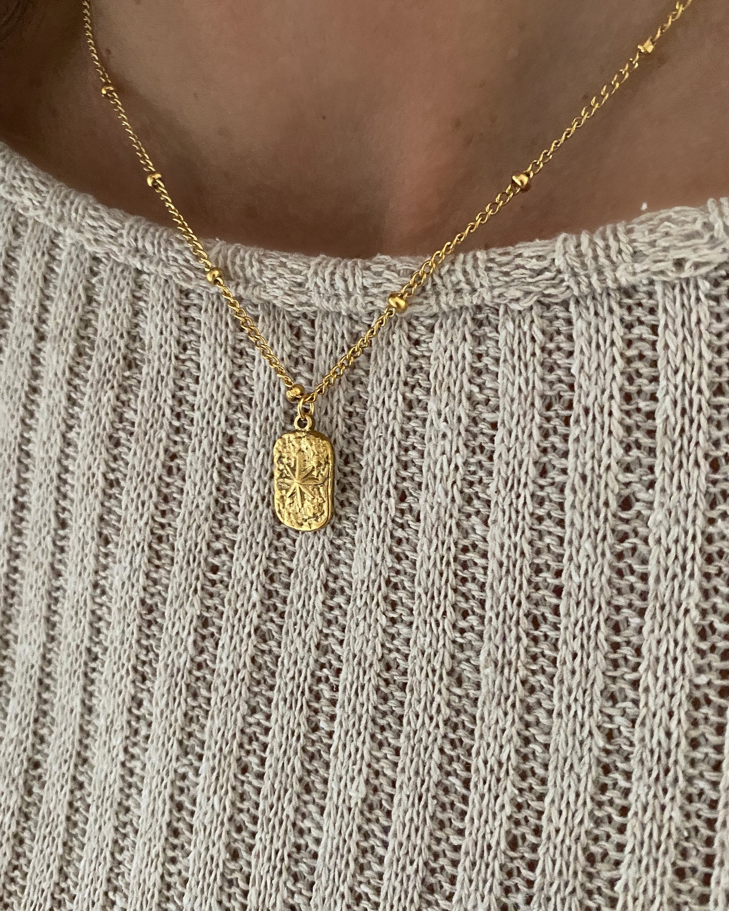 Collar con cadena de bolitas y colgante textura estrella en acero acabado oro Estrella De Oriente
