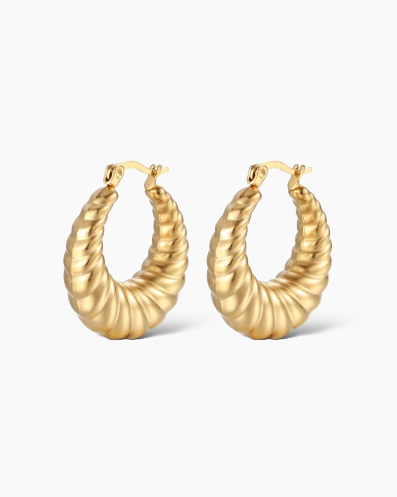 Los pendientes Aros Nawa tienen diseño de textura trenzada, en acero inoxidable bañado en oro de 18k.