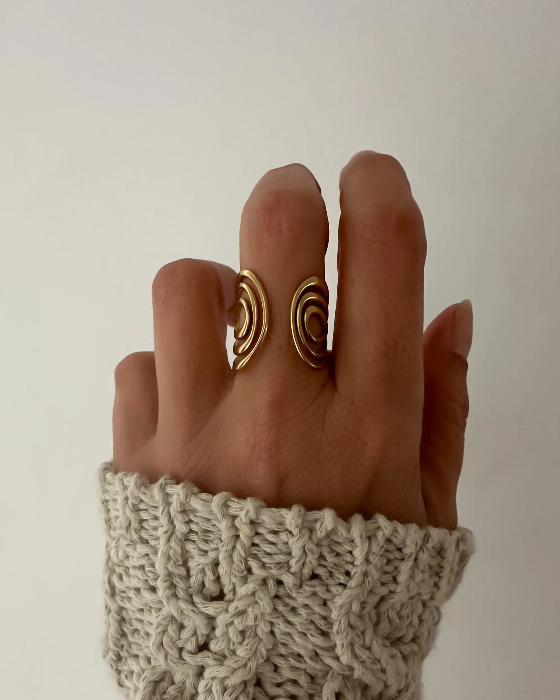 Anillo abierto ajustable con diseño ondulado como las olas del mar, en acero inoxidable bañado en oro.