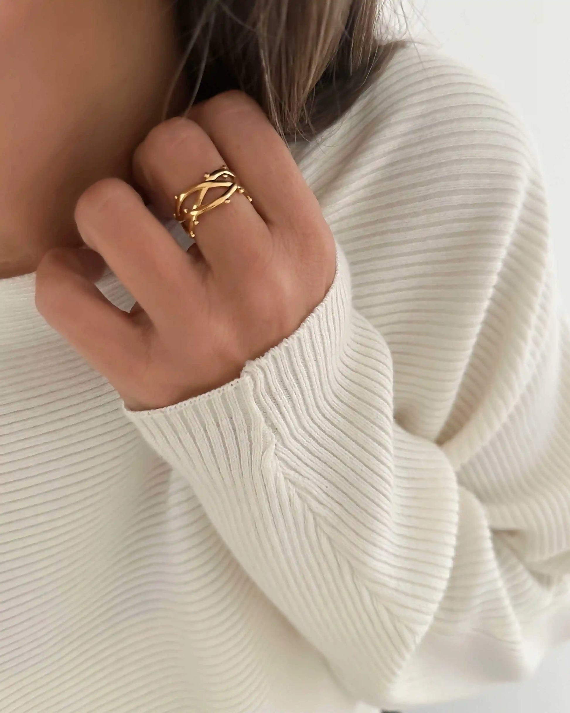 Anillo abierto ajustable con diseño trenzado con bolitas, en acero inoxidable bañado en oro.