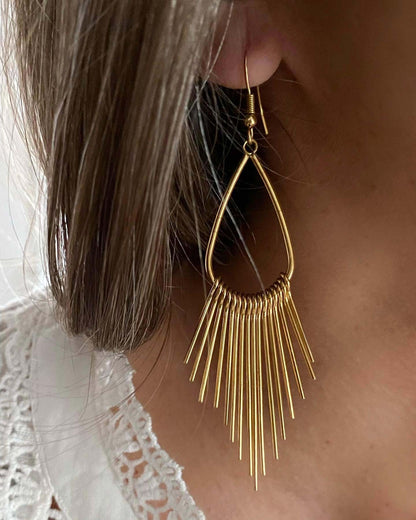 Los PENDIENTES SIXTIES son unos pendientes largos de acero inoxidable con baño de ORO, con cierre de gancho y forma de lagrima con colgantes de barritas.